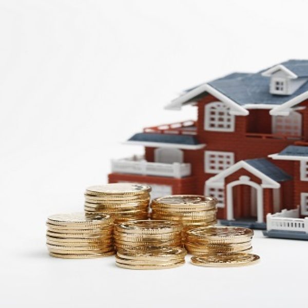 RMB coins stacked in front of the housing model (house prices, house buying, real estate, mortgage concept)