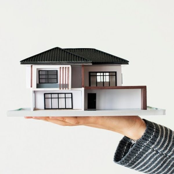 Hand presenting model house for home loan campaign